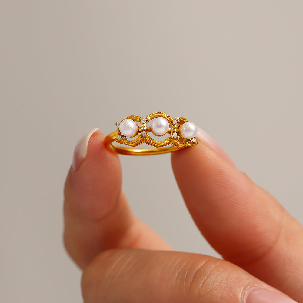 A golden stainless steel ring set with pearls