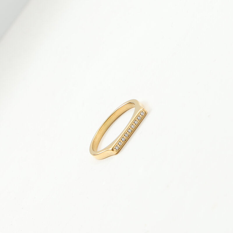 A golden stainless steel D-shaped ring set with fine diamonds