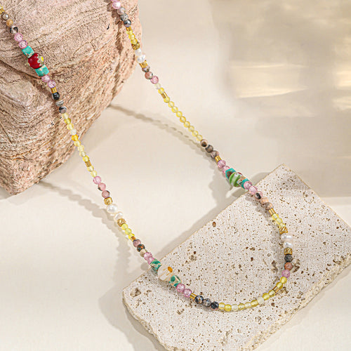 A hand-beaded necklace made of colored natural stone pearls