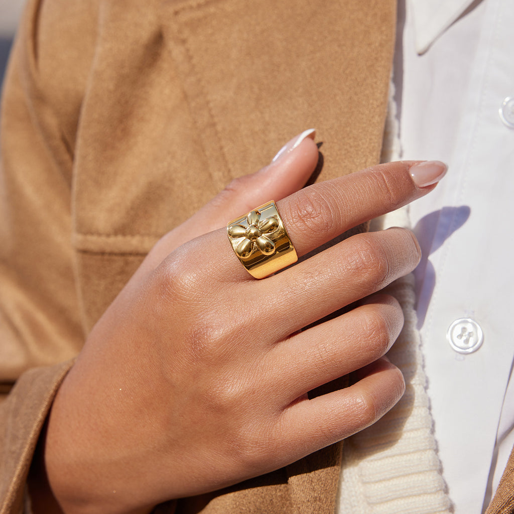A golden stainless steel wide-face flower ring