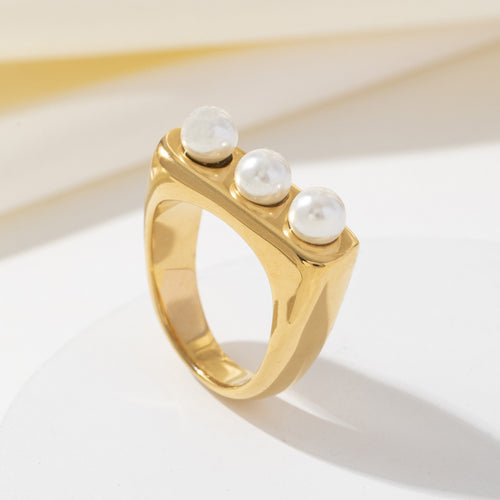 A rectangular stainless steel ring inlaid with pearls