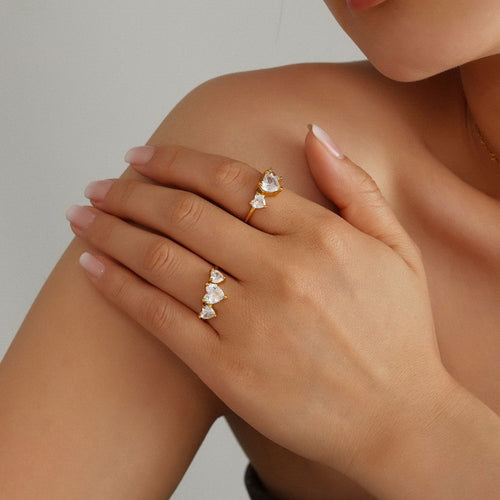 A stainless steel ring set with three heart-shaped zircon stones