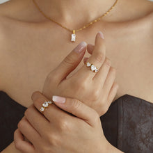 Load image into Gallery viewer, A stainless steel ring set with three heart-shaped zircon stones