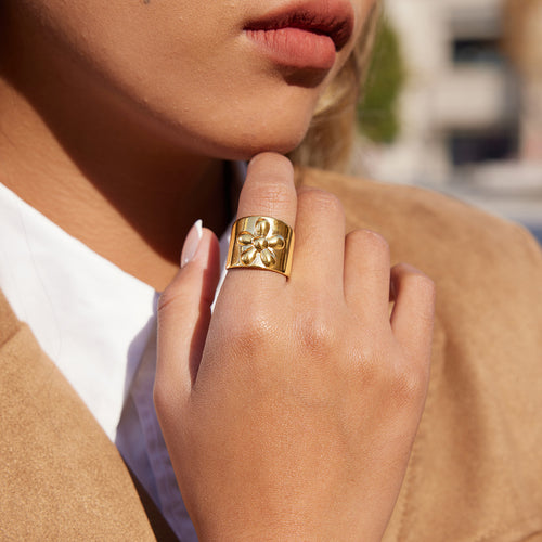 A golden stainless steel wide-face flower ring
