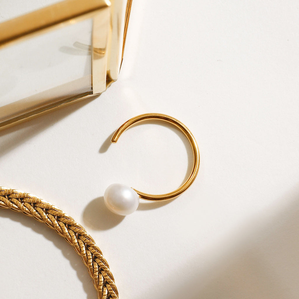 A stainless steel ring set with pearls