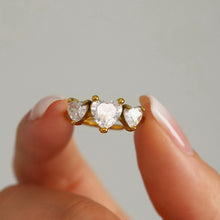 Load image into Gallery viewer, A stainless steel ring set with three heart-shaped zircon stones
