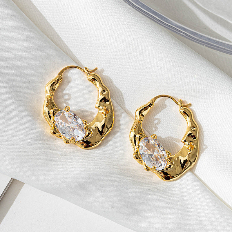 Irregularly shaped round ear loops inlaid with zirconium