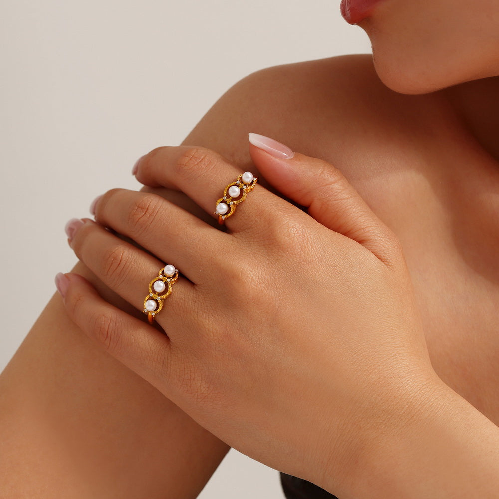 A golden stainless steel ring set with pearls