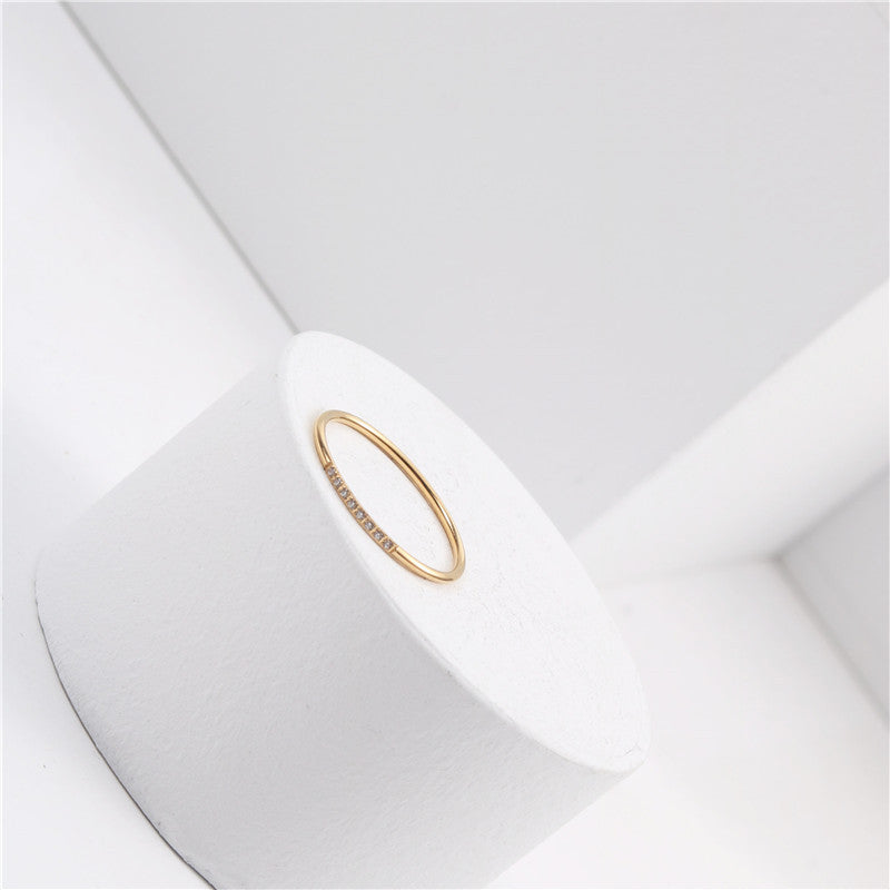 A small diamond-encrusted titanium steel index finger ring plated with 18K gold