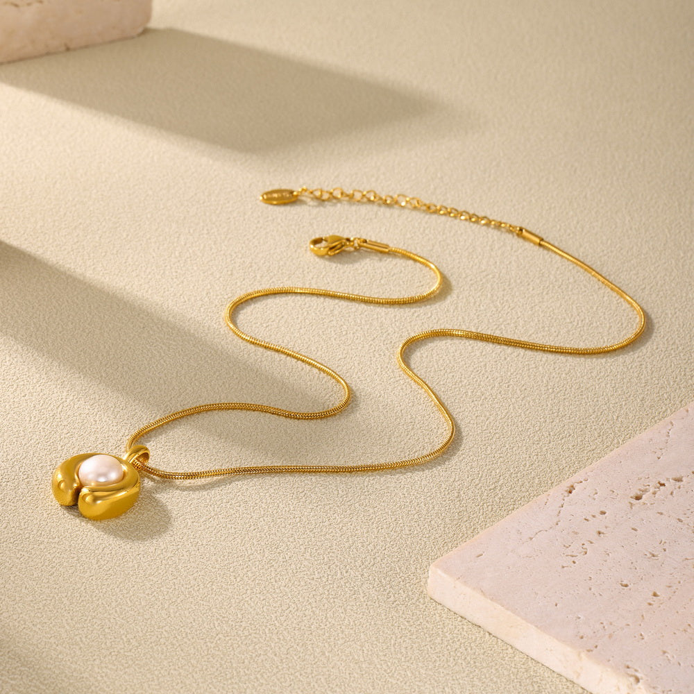 A C-shaped freshwater pearl pendant necklace made of stainless steel plated with 18K gold