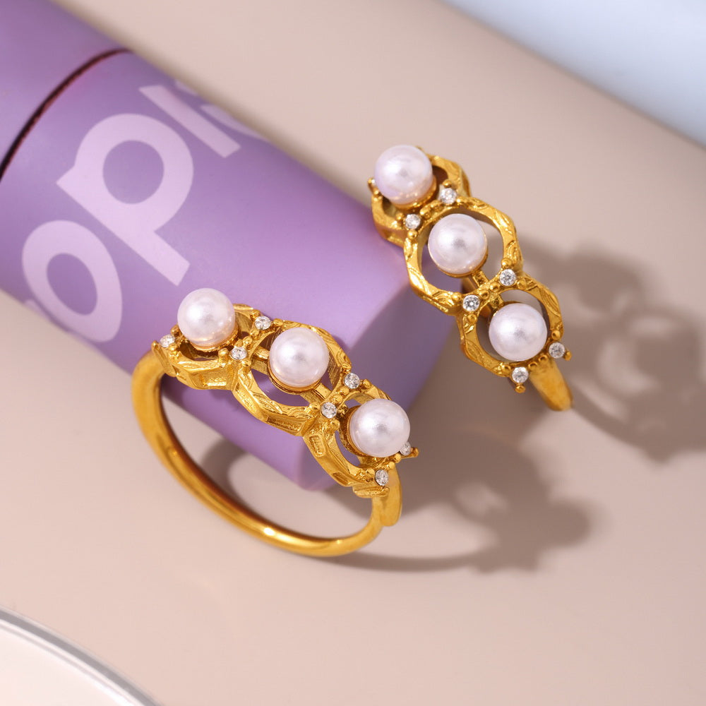 A golden stainless steel ring set with pearls