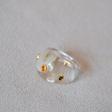 Load image into Gallery viewer, A transparent resin ring set with colored zircon